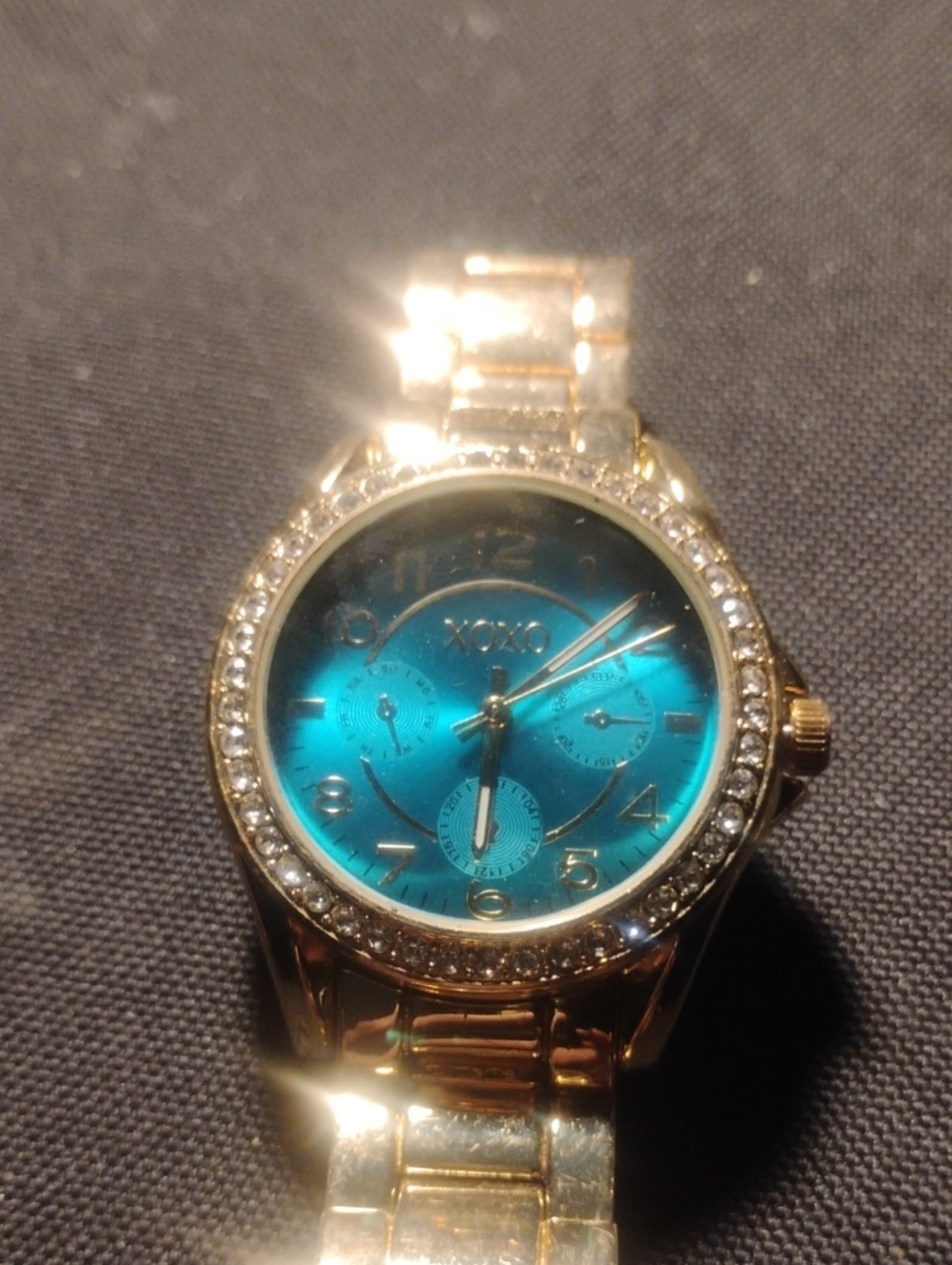 XOXO Gold Tone Bracelet Watch with Teal Dial and Crystal Bezel